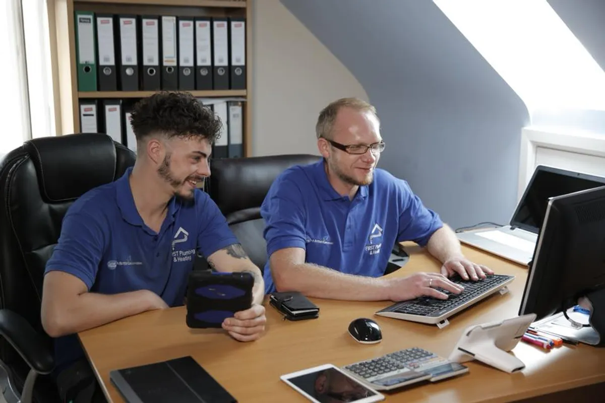boy in black hoodie writing on white paper